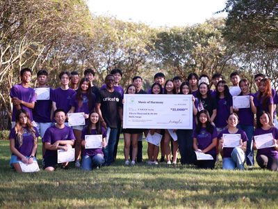 Group stands with check for donation.