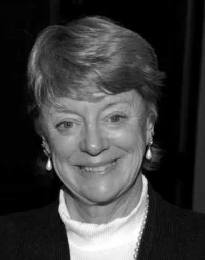 Black-and-white headshot of an older woman with short light hair, smiling.