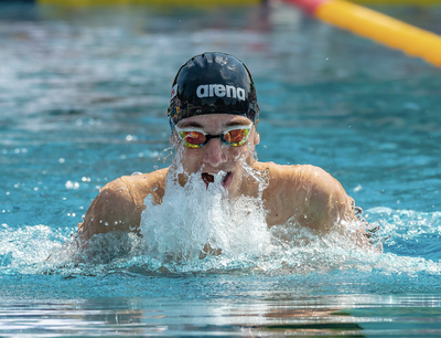 Swimmer doing a breast stroke in a pool.