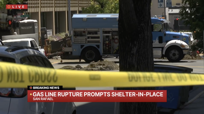 PG&E utility trucks and crews behind police tape at Fifth Avenue and B Street in San Rafael, with a KRON 4 breaking-news banner reading "Gas line rupture prompts shelter-in-place."