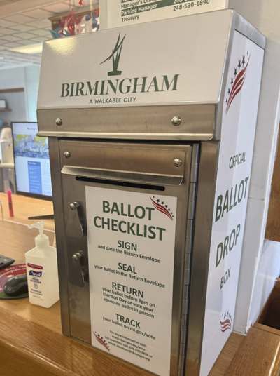 An official Birmingham ballot drop box inside City Hall, labeled "Ballot Checklist" with instructions to sign, seal, return, and track your ballot.
