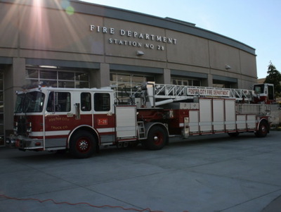 Foster City Fire Department ladder truck parked outside a fire station.